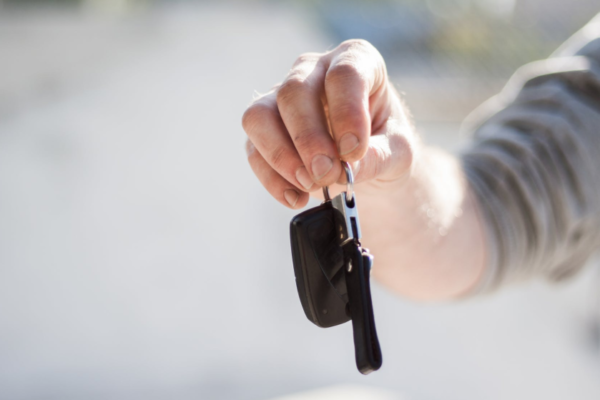 A man hands over some keys to a new car buyer